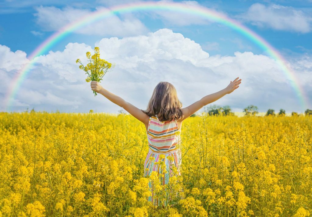 A child in a yellow rainbow field. Selective focus.