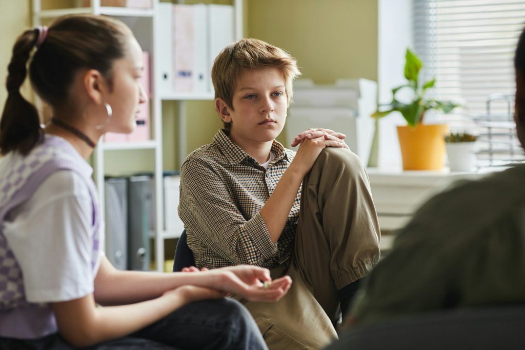 Difficult kid sitting at psychology group