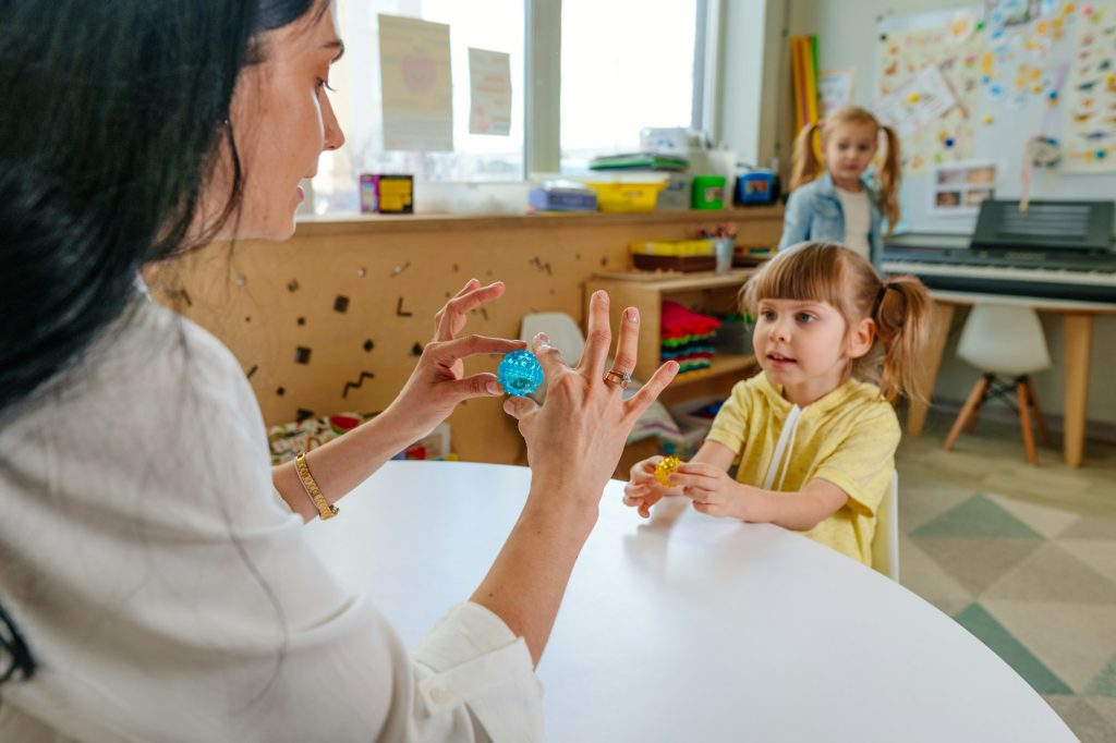 Girl on the lesson of the development of fine motor skills in kindergarten